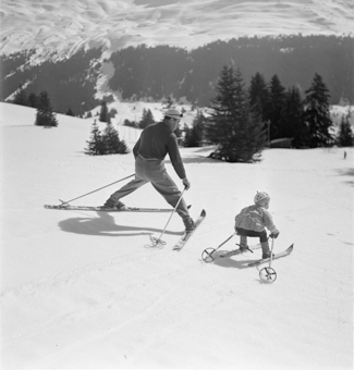 Kind und Skilehrer nebeneinander in Fahrt