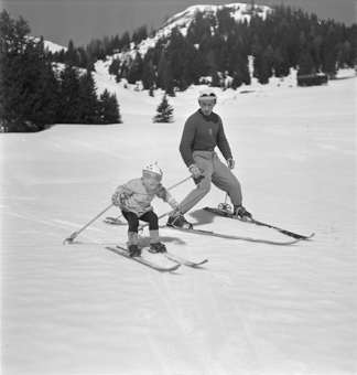 Kind und Skilehrer nebeneinander in Fahrt