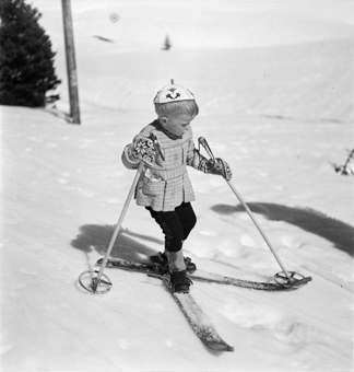 Kind mit gekreuzten Skiern