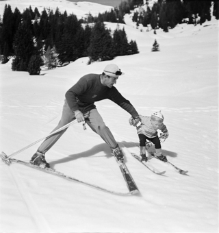 Kind und Skilehrer Hand in Hand in Fahrt