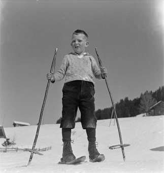 Knabe mit Fassdauben (kurzen Skis) und Skistöcken