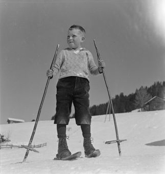 Knabe mit Fassdauben (kurzen Skis) und Skistöcken