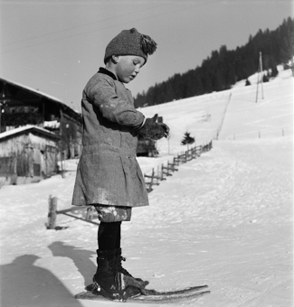 Kind mit Fassdauben (kurzen Skis) und Winterkleidung