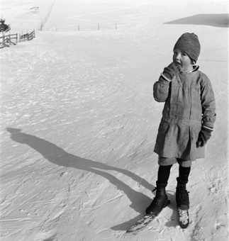 Kind mit Fassdauben (kurzen Skis) und Winterkleidung