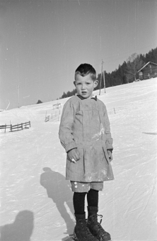 Bauernkind mit Fassdauben (kurzen Skis) an einem Schneehang