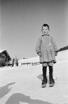 Bauernkind mit Fassdauben (kurzen Skis) an einem Schneehang