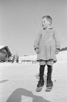 Bauernkind mit Fassdauben (kurzen Skis) an einem Schneehang