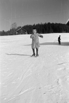 Bauernkind mit Fassdauben (kurzen Skis) an einem Schneehang
