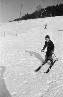 Mädchen fährt auf Skiern einen Hang runter