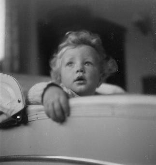 Porträt eines staunenden Kleinkindes in Kinderwagen sitzend
