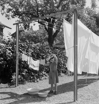 Mädchen beim Wäschehängen in städtischem Garten