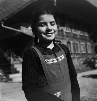 Porträt eines jungen Mädchens vor einem Bauernhaus