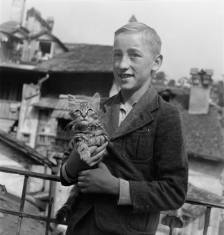 Knabe mit einer jungen Katze auf Terrasse der Altstadt