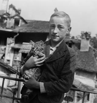 Knabe mit einer jungen Katze auf Terrasse der Altstadt