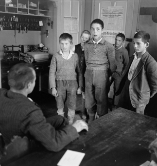 Gruppe von Knaben im Büro des Heimleiters