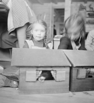 Mädchen beim Spiel mit Puppenhaus