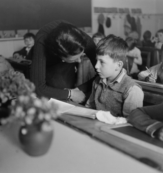 Lehrerin mit Schüler in Schulzimmer