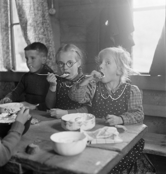 Kinder beim Essen in ländlicher Stube