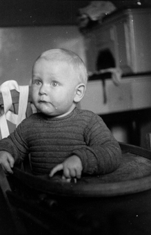 Kleinkind in Kinderstuhl sitzend