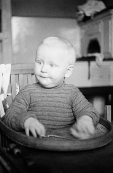 Kleinkind in Kinderstuhl sitzend