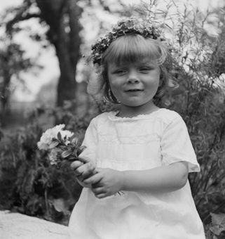 Kleines Mädchen in weissem Sommerkleid mit Blumenkranz und Blumensträusschen