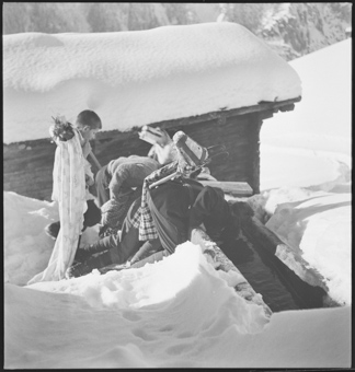 Mehrere Jungen mit Verkleidungen trinken im Schnee aus dem Brunnen