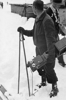 Mann mit Telefonapparat auf den Gelände des Skispringens