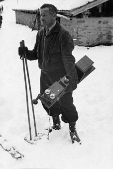Mann mit Telefonapparat auf den Gelände des Skispringens