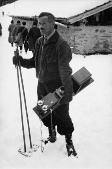Mann mit Telefonapparat auf den Gelände des Skispringens
