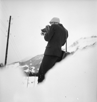 Fotograf oder Fotografin mit Kamera in Aktion an Skispringen