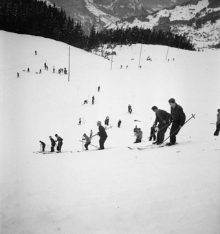 Männer mit Skis am Ausbessern der Piste von Skispringen