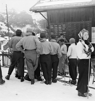 Gruppe von Skifahrern bei der Resultatetafel eines Skirennens