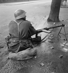 Unruhen von Genf 1932: Soldat mit Gewehr am Strassenrand sitzend