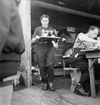 Frau mit Kaffeegläsern in Bergrestaurant