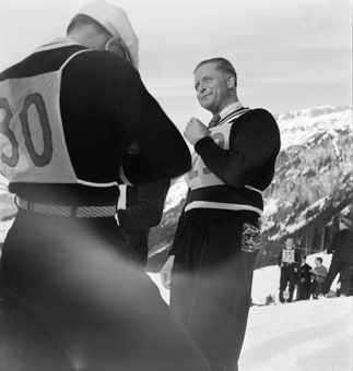 Skispringer mit Start-Nummern am Warten