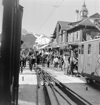 Wintersportlerinnen und -sportler mit Skis und Schlitten, Peroons, Gleise, Züge, Zug mit Ski-Transportwagen
