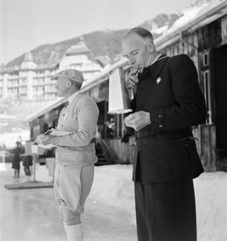 Im Hintergrund eine Zuschauertribune und das Hotel Victoria-Lauberhorn