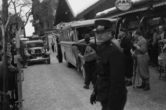 Hochbetrieb im Dorfzentrum von Adelboden mit wartenden Skifahrern, Bus und Automobil