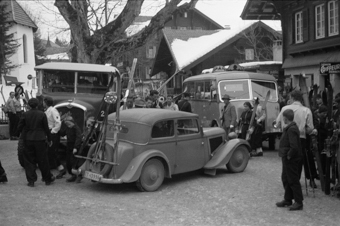Hochbetrieb im Dorfzentrum von Adelboden mit wartenden Skifahrern, Bussen und Auto