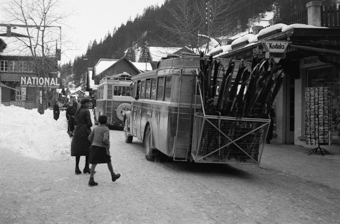 Zwei Busse mit Skis beladen fahren durch das Dorfzentrum von Adelboden
