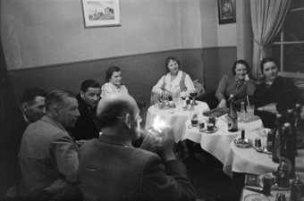 grössere Runde von Leuten an mehreren kleinen Tischchen mit diversen Getränken