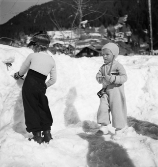 Zwei kleine Kinder beim Schneeschaufeln