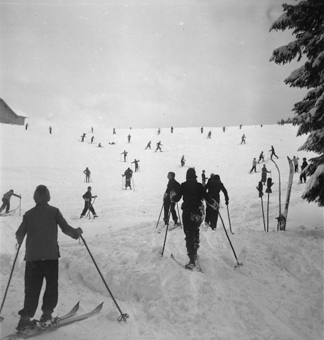 Schneehang mit zahlreichen Skifahrern am Hinaufmarschieren 