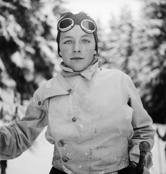 Knabe mit Skijacke, Skibrille und Skistöcken