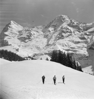 Drei Skifahrer vor Eiger und Mönch