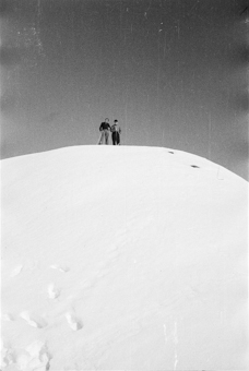 Zwei Buben auf Skiern den Schneehang herunterblickend
