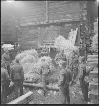 Soldaten bei der Arbeit mit Holz und Heuballen