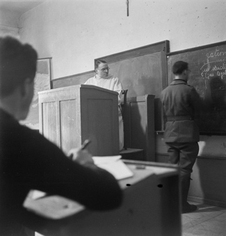 Schulzimmer mit Priester und Soldaten