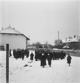 Gruppe von Spahis (Internierte) auf verschneiter Wiese neben Scheune