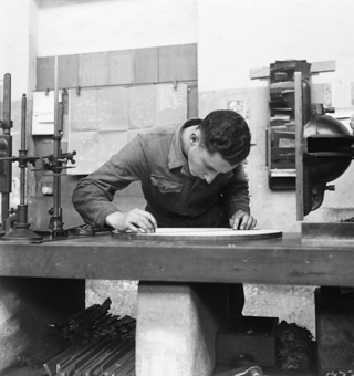 Arbeiter an Werkbank beim Ausmessen